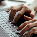 Fotografía de una mano sobre el teclado de un computador